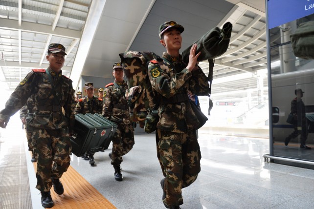 Soldiers carry supplies and equipments to board a train at Lanzhou West Railway Station in Lanzhou, northwest China's Gansu Province. (Image source: IANS)